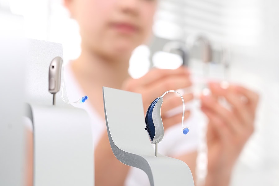 2 Hearing aids on stands and girl in background